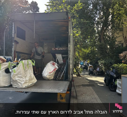 משאית הובלה עם אדם וציוד על המדרכה